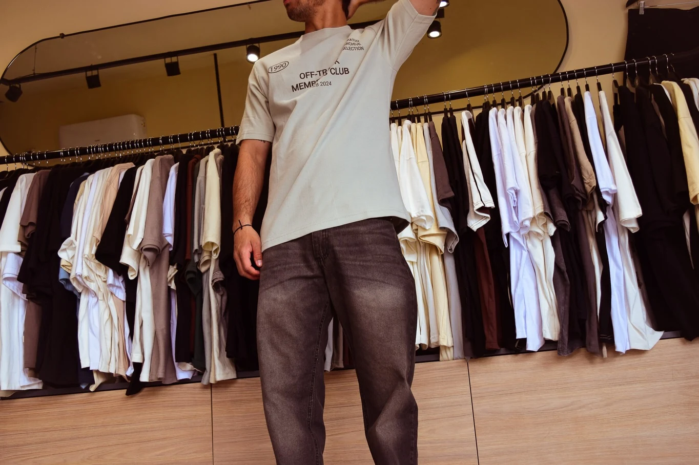 Remera y pantalón de Drop frente al perchero del local